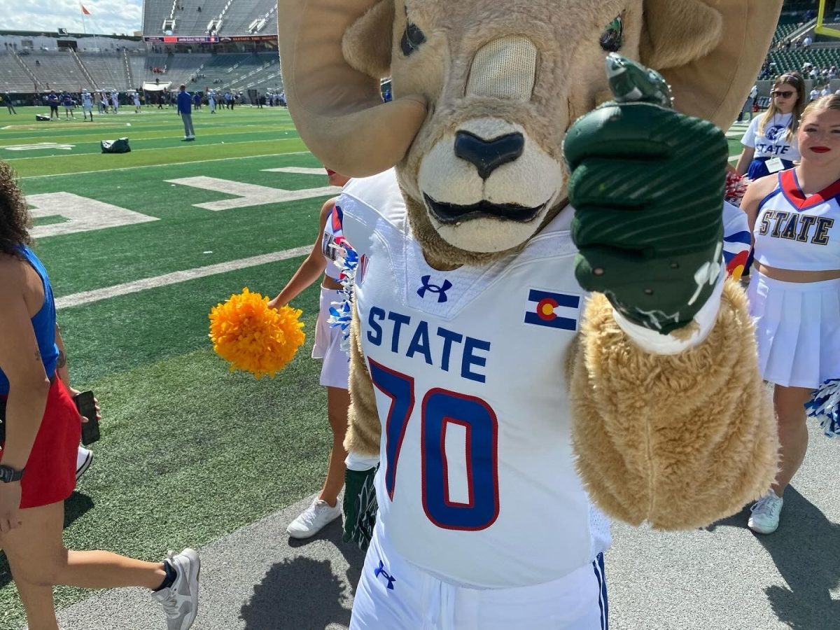 Cam the Ram in his state pride uniform giving out a fist bump in the endzone with the cheerleaders at Canvas Stadium